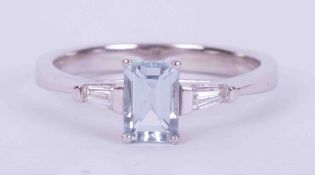 An 18ct white gold ring set with a central emerald cut aquamarine, approx. 0.66 carats, set to