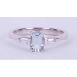 An 18ct white gold ring set with a central emerald cut aquamarine, approx. 0.66 carats, set to