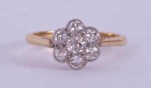 An 18ct yellow & white gold flower cluster ring set with seven old round cut diamonds, total diamond