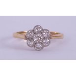 An 18ct yellow & white gold flower cluster ring set with seven old round cut diamonds, total diamond