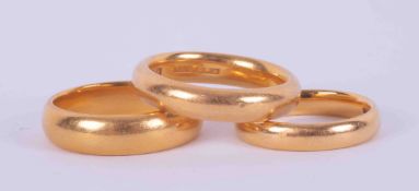 Three 22ct yellow gold wedding bands, one 4.7mm wide, size K 1/2 and 6.59gm, one 3.3mm wide, size