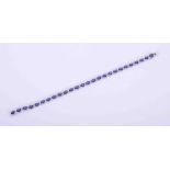 An 18ct white gold bracelet set with 10 carats of oval cut sapphires interspaced with 0.55 carats of