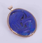 A 9ct yellow gold brooch/pendant set with carved lapis lazuli, 15.22gm, 4.5cm x 4cm (not including