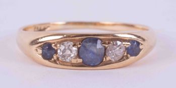 An 18ct yellow gold ring, set with two round cut sapphires & a central set oval cut sapphire,