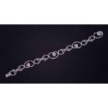 An 18ct white gold swirl design bracelet set with small round cut diamonds and eight round cut