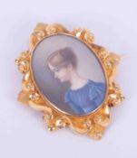 A yellow gold (not hallmarked or tested) ornate portrait miniature brooch of a girl in a blue dress,