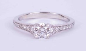 A fine platinum ring set with a central round brilliant cut diamond, 0.60 carats, colour F and SI1