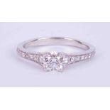 A fine platinum ring set with a central round brilliant cut diamond, 0.60 carats, colour F and SI1