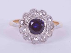 An 18ct yellow gold & platinum flower cluster style ring set central with a round cut sapphire,