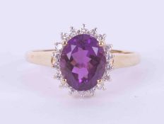 A 9ct yellow gold cluster ring set with an oval cut amethyst, approx. 2.50 carats, surrounded by