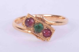 A yellow gold (not hallmarked or tested) ring set with two round cut rubies and a round cut emerald,