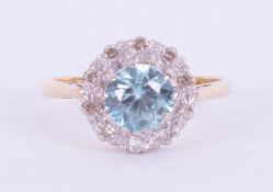 An 18ct yellow & white gold cluster ring set with a central round cut blue zircon, approx. 1.00