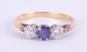 A yellow & white gold (not hallmarked or tested) three stone ring set with a central round cut