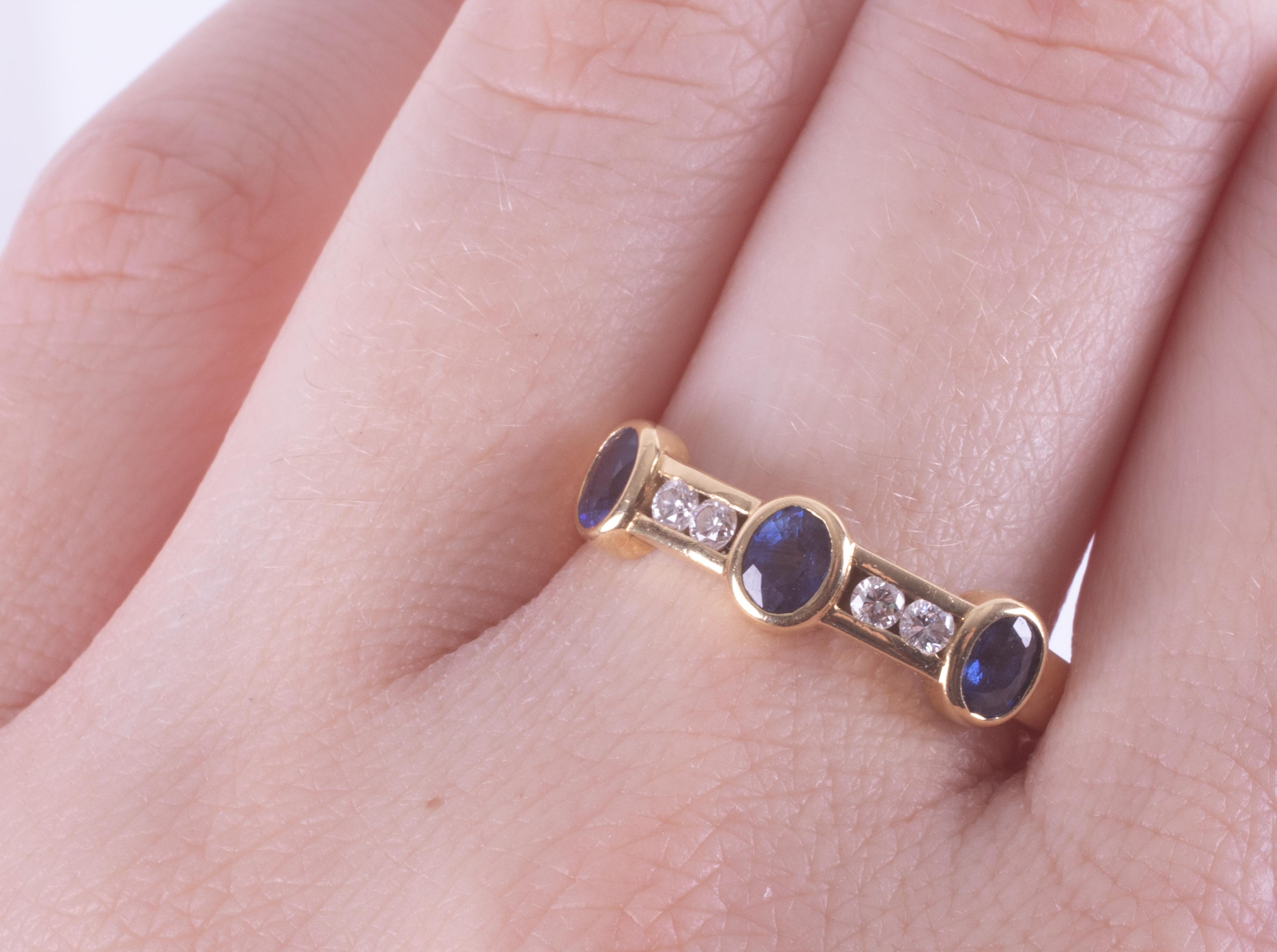 An 18ct yellow gold band set with three oval cut sapphires, total weight approx. 0.63 carats with - Image 2 of 2