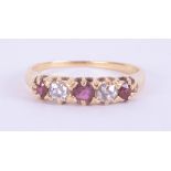 An 18ct yellow gold five stone ring set with two round cut rubies & one cushion cut ruby, total