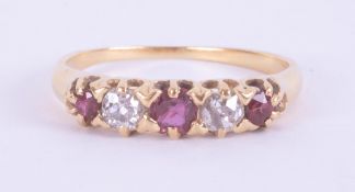 An 18ct yellow gold five stone ring set with two round cut rubies & one cushion cut ruby, total