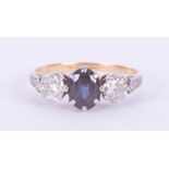 An 18ct yellow & white gold three stone ring set with a central oval cut sapphire approx. 0.62