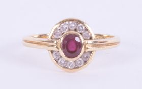 An 18ct yellow gold modern design cluster style ring set with a central oval cut ruby, approx. 0.