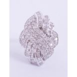An ornate 18ct white gold cocktail ring set with a mixture of round brilliant cut & baguette cut