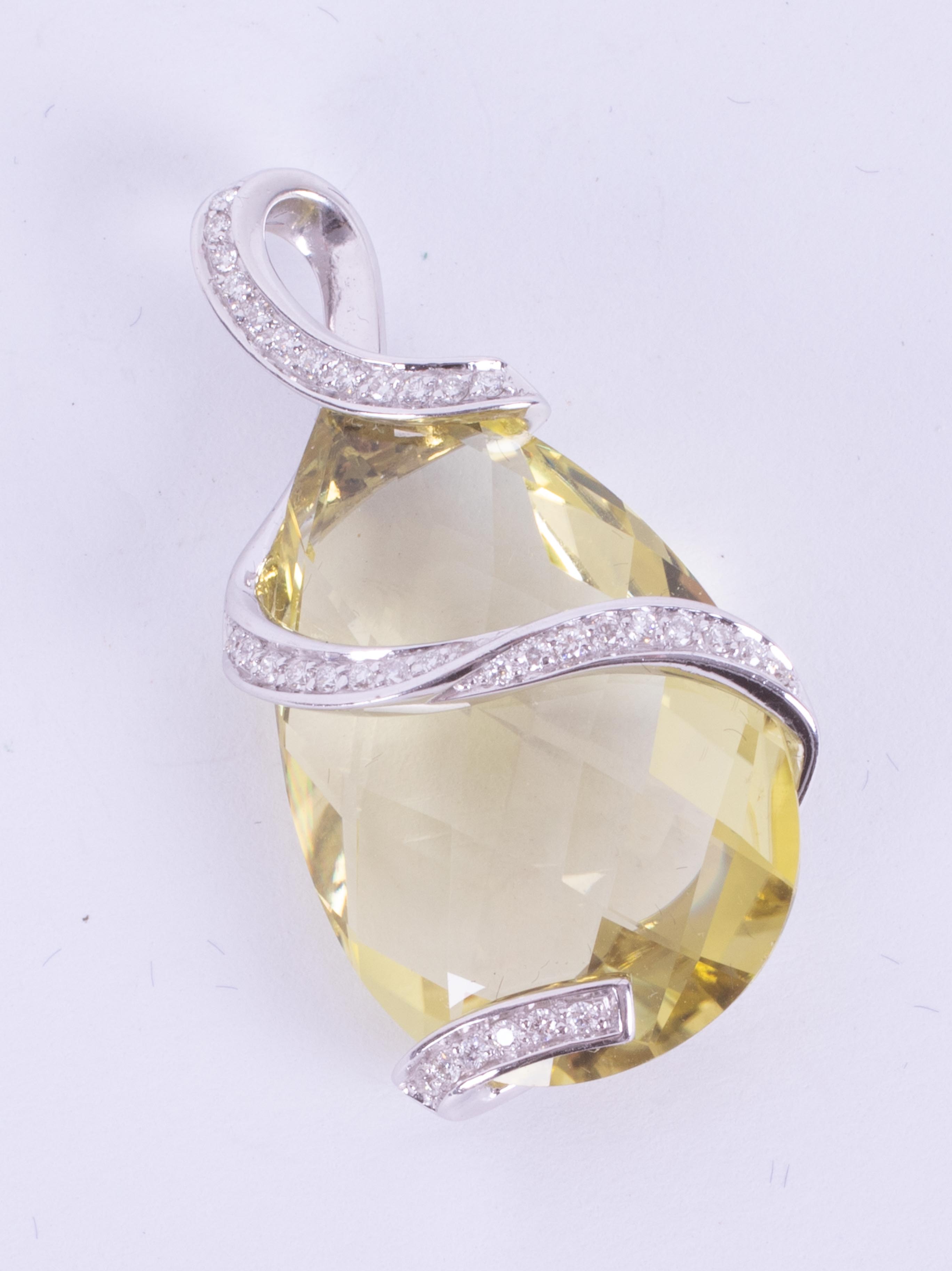 An impressive 14k white gold pendant set with a mixed cut pear shaped lemon quartz measuring