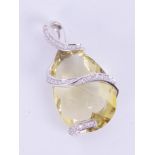 An impressive 14k white gold pendant set with a mixed cut pear shaped lemon quartz measuring