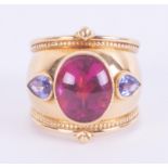 An 18ct yellow gold designer ring by Theo Fennell, set with a central oval cabochon & faceted cut