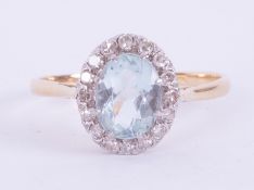 An 18ct yellow gold & platinum cluster ring set with an oval cut aquamarine measuring approx. 9mm