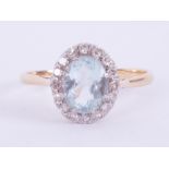 An 18ct yellow gold & platinum cluster ring set with an oval cut aquamarine measuring approx. 9mm