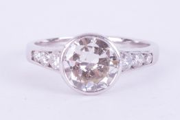 An 18ct white gold ring set with a central rub over set round brilliant cut diamond, approx. 2.20