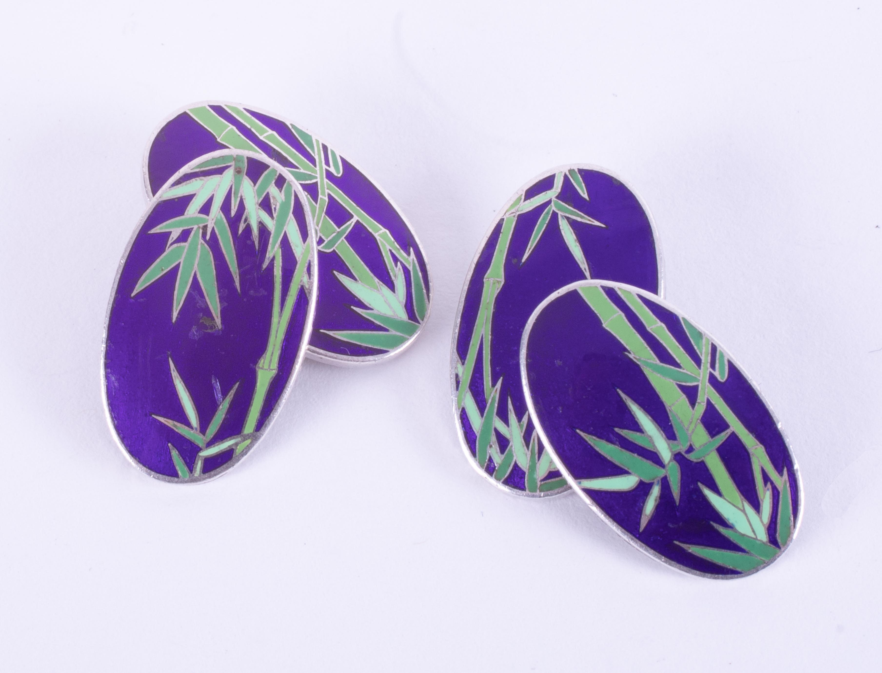 A pair of oval silver & enamel cufflinks with a bamboo design, approx. 1.9cm length x 1cm width,