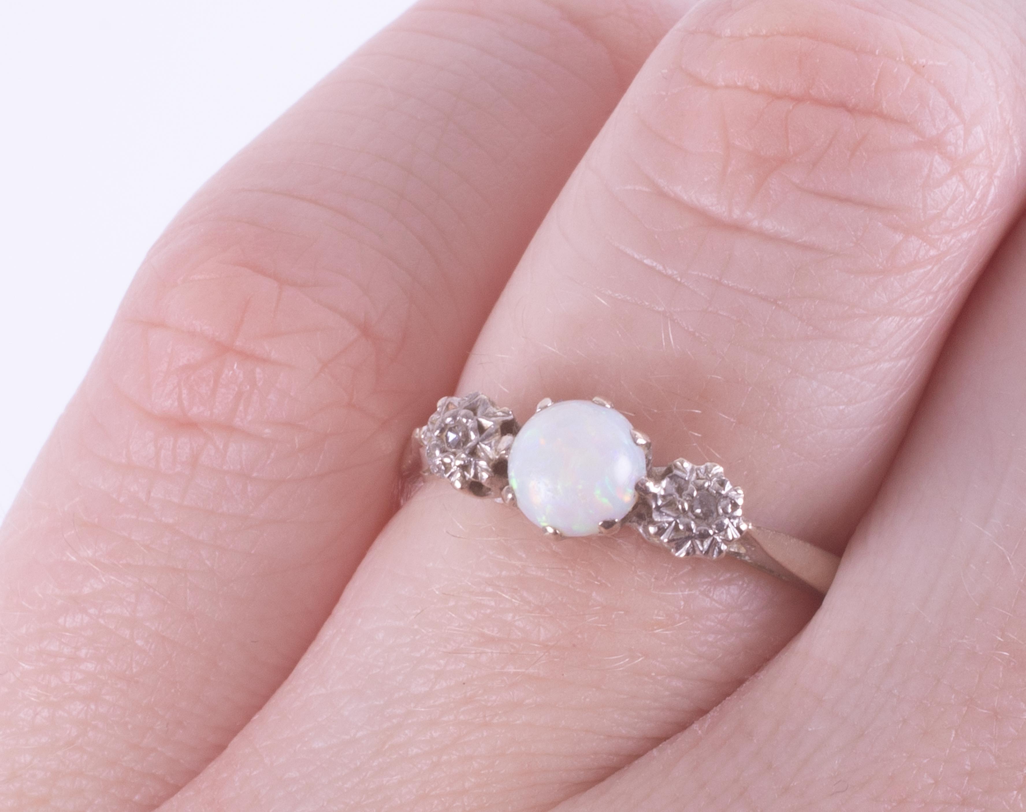An 18ct white gold three stone ring set with a central cabochon cut white opal, 5.4mm with one round - Image 2 of 2