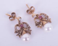 A pair of 9ct yellow gold ornate 'bow' design drop earrings set with small round cut rubies &