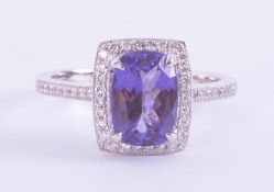 A 14k white gold cluster ring set with a central cushion cut Tanzanite, approx. 2.10 carats,