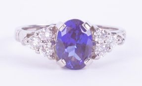 A fine platinum ring set with a central oval cut tanzanite of approx. 1.80 carats set each side with