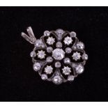 An Edwardian gold (not hallmarked or tested) flower style pendant set with old round cut diamonds,