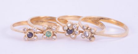 A set of four 18ct yellow gold stacking rings with a flower design set with small round brilliant