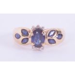 A 9ct yellow gold ring set with a central oval cut sapphire approx., 0.52 carats, with three