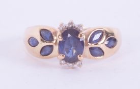 A 9ct yellow gold ring set with a central oval cut sapphire approx., 0.52 carats, with three