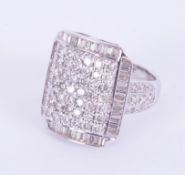 An ornate 18ct white gold square shaped cluster ring set with a mixture of round brilliant cut
