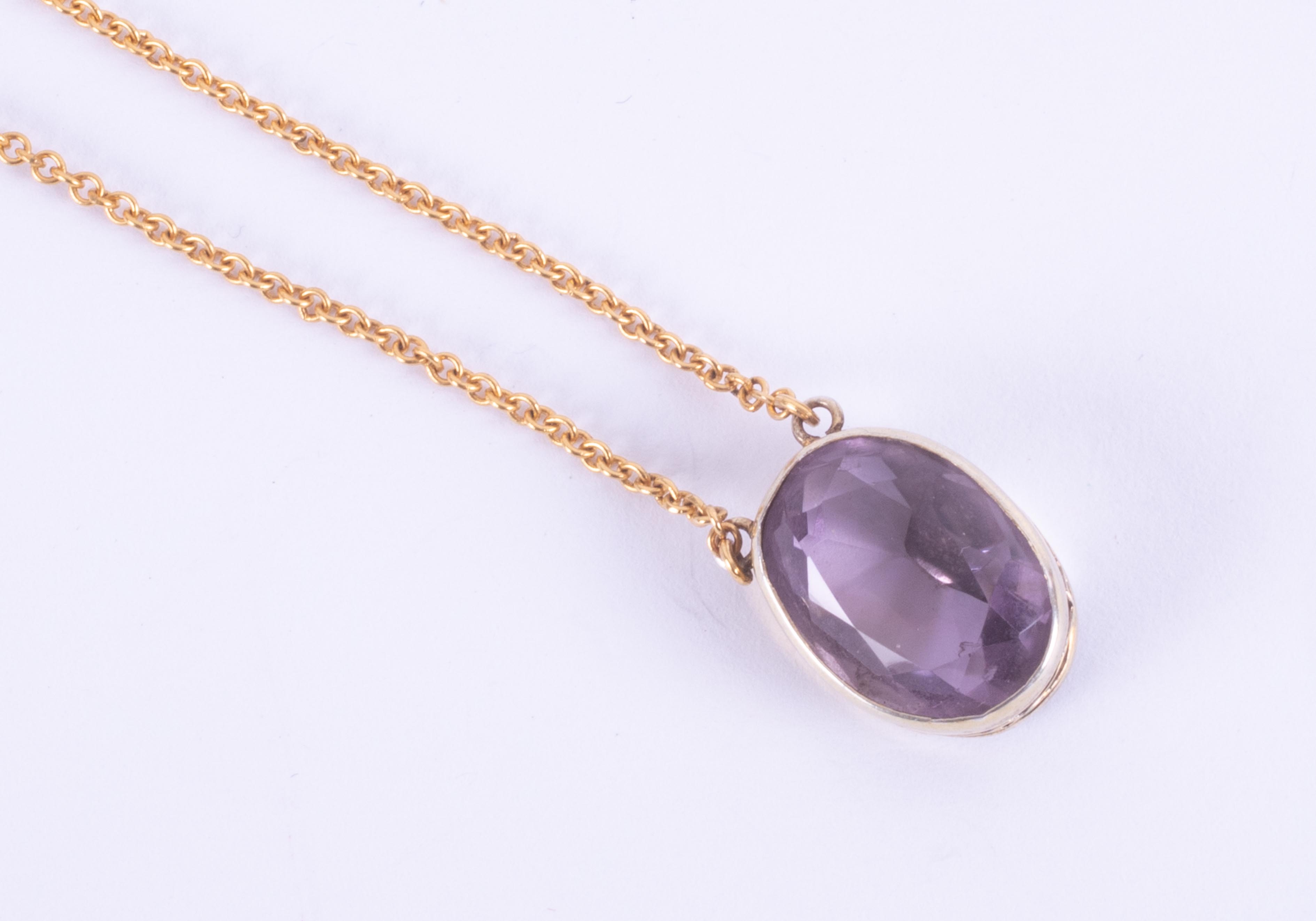 A 9ct yellow gold pendant set with an oval cut amethyst measuring approx. 15mm x 11mm on a yellow