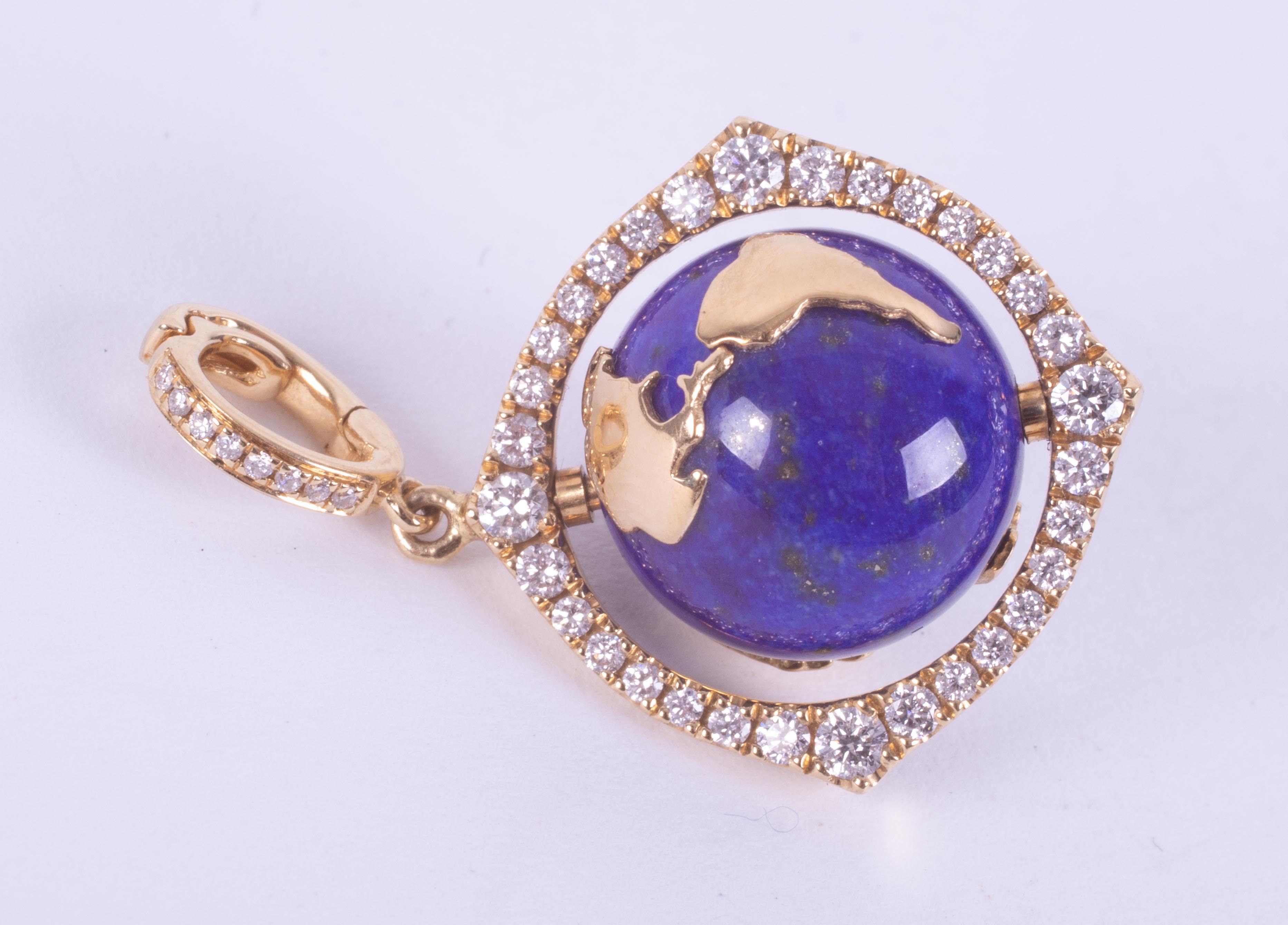 An 18ct yellow gold pendant set with a spinning lapis lazuli & gold 'World' surrounded by small