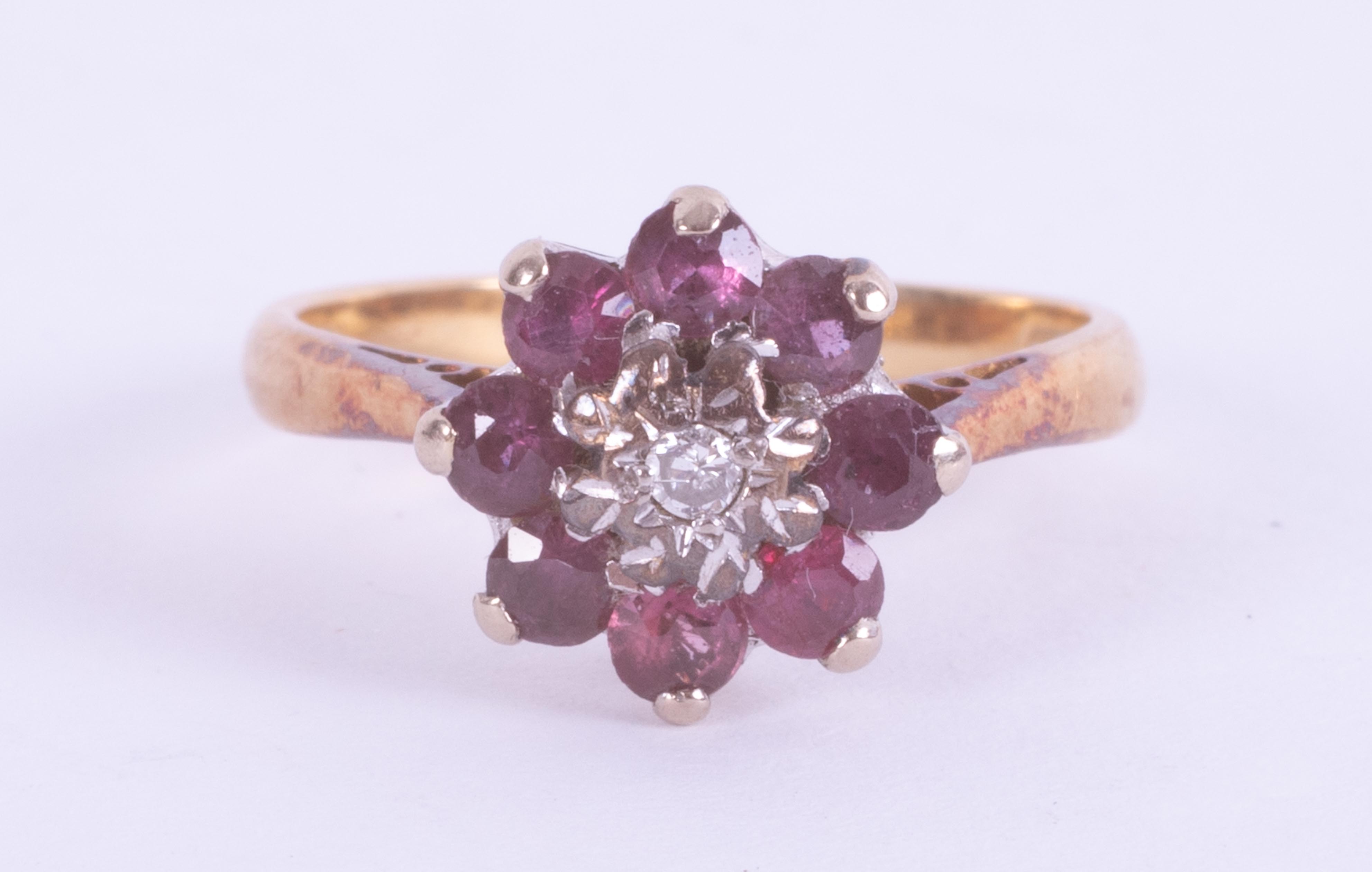 An 18ct yellow gold cluster ring set with a small central round cut diamond, surrounded by round cut