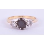 An 18ct yellow gold & platinum three stone ring set with a central oval cut dark blue sapphire,