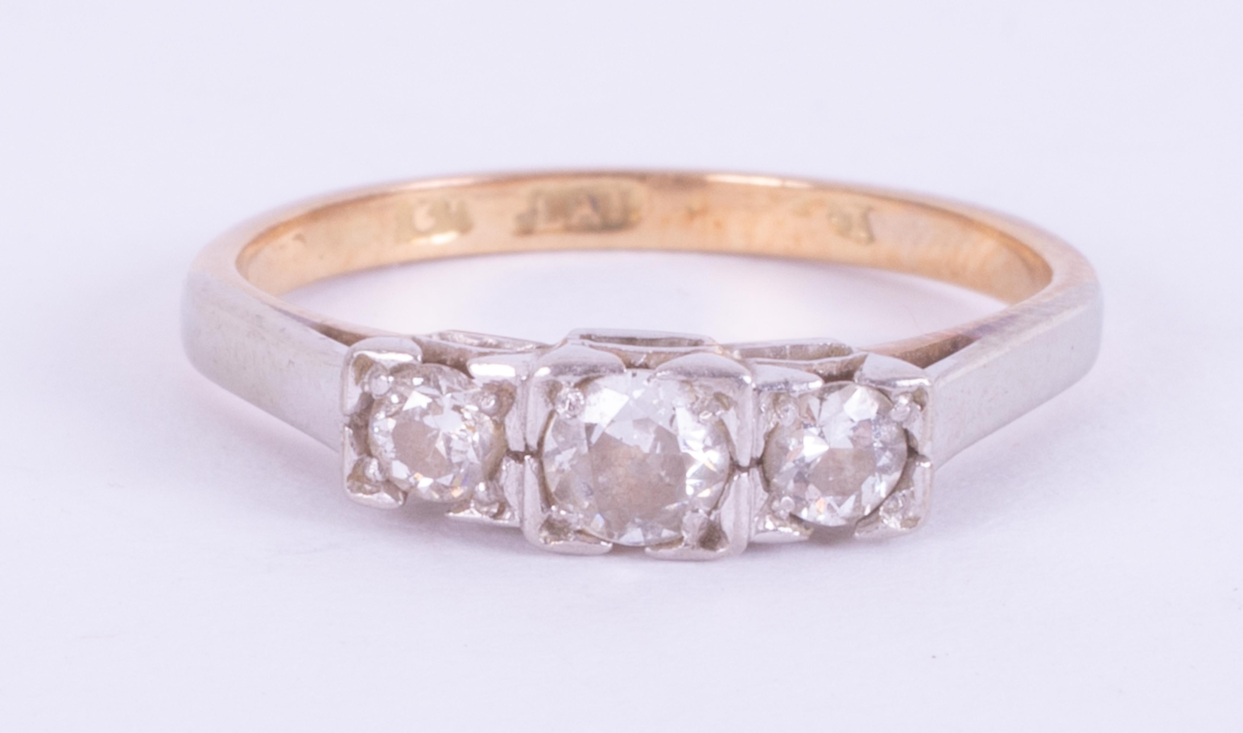 An 18ct yellow & white gold three stone ring set with three round cut diamonds, approx. total
