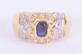 An 18ct yellow & white gold ornate design ring set with a central emerald cut sapphire approx. 0.