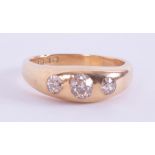 An 18ct yellow gold gent's ring set with three old cut diamonds, the two outer diamonds of a round