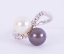 A white gold (not hallmarked or tested) crossover style ring set with a 7.6mm black & white pearl