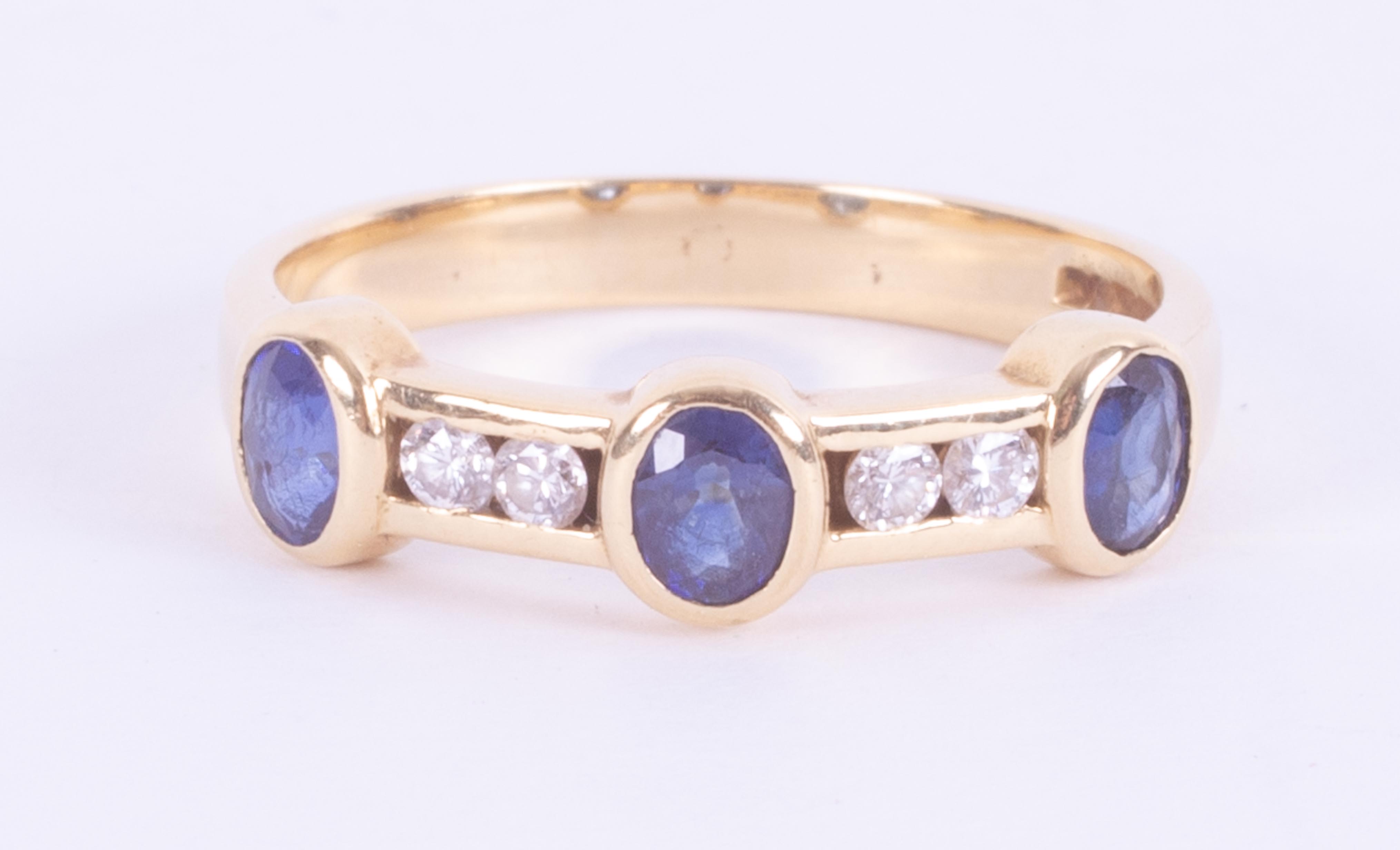 An 18ct yellow gold band set with three oval cut sapphires, total weight approx. 0.63 carats with