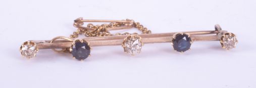 A yellow gold (not hallmarked or tested) bar brooch set with three round cut diamonds, total