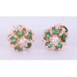 A pair of 14k yellow gold flower cluster earrings set with a central round cut diamond and